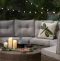Image of a comfy patio set with lit candles and glowing string lights