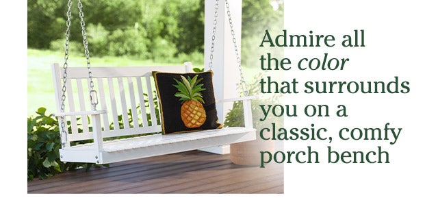 Admire all the color that surrounds you on a classic, comfy porch bench