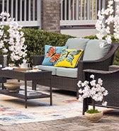 Create A Stylish Outdoor Room. Image of a Hawthorne wicker seating set and patio decorations.