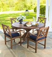 Best Woods For Outdoor Furniture > Image of a round eucalyptus wood Claremont dining table and chairs on a patio.