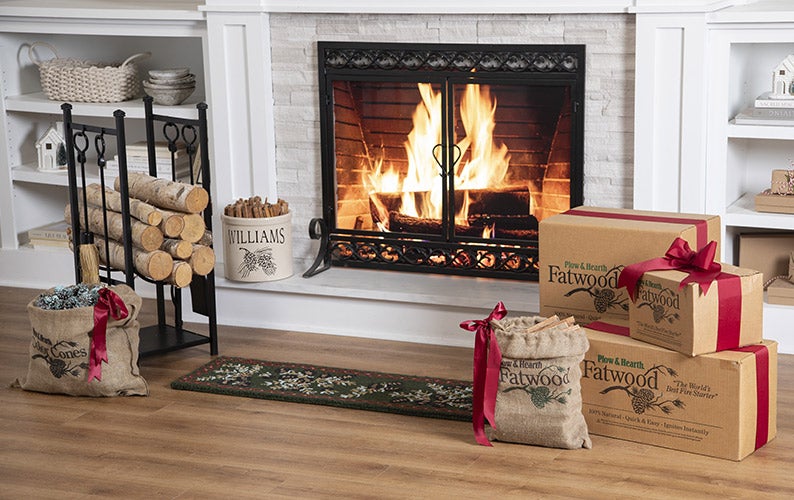 Image of Fire in fireplace with fire screen, fatwood boxes and log rack with fireplace tools