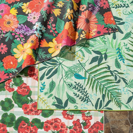 close up image of 3 colorful patterned outdoor rugs laying on top of each other