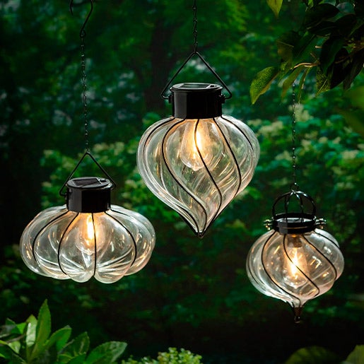 3 hanging solar lanterns with swirled glass and metal frame to house a solar powered Edison-style bulb