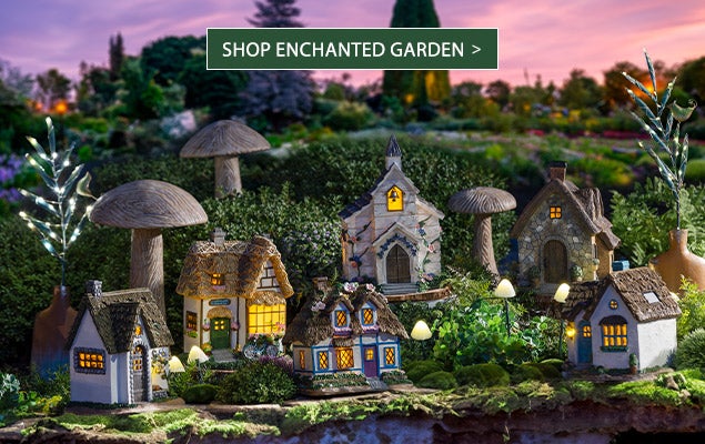 Image of assorted mini fairy houses at night. SHOP ENCHANTED GARDEN