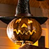 A lighted halloween jack-o-lantern scarecrow head glows from within