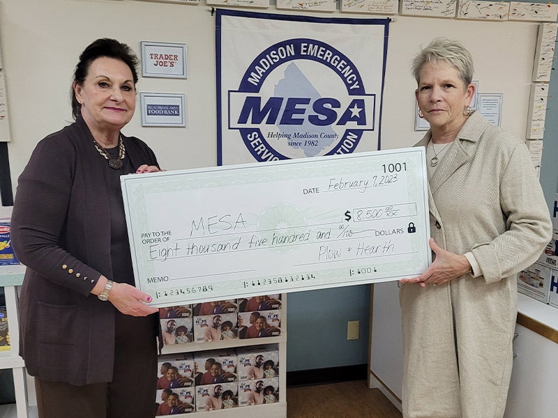 women holding large check
