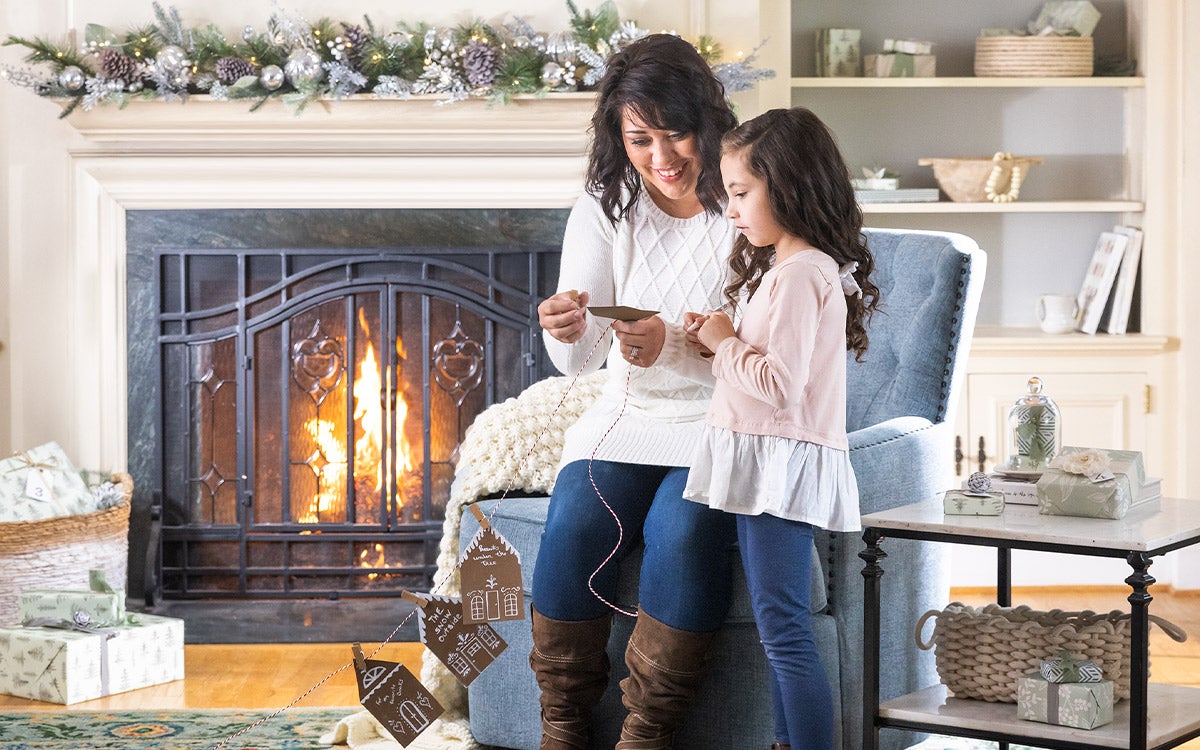 woman making garland with child in living room