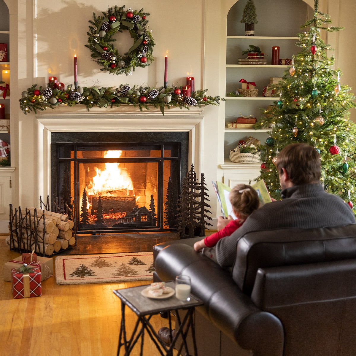 father and child reading in front of fireplace