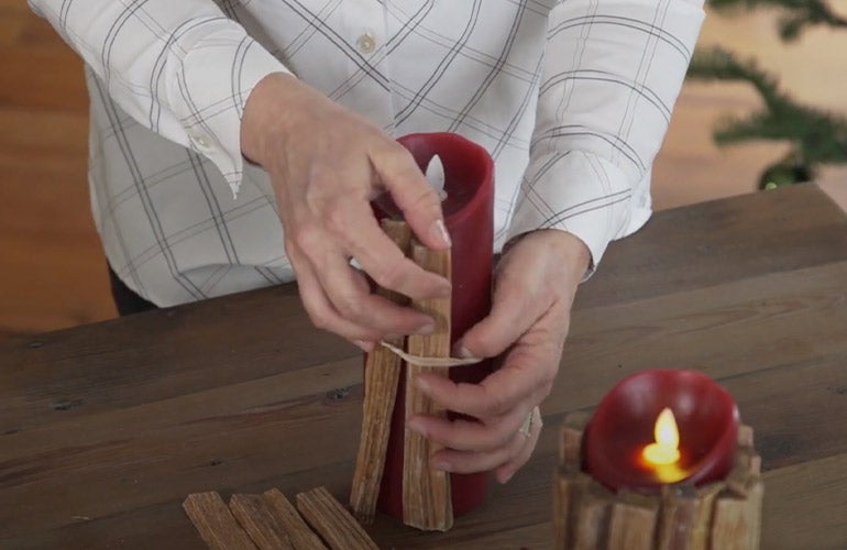 woman putting fatwood on candle