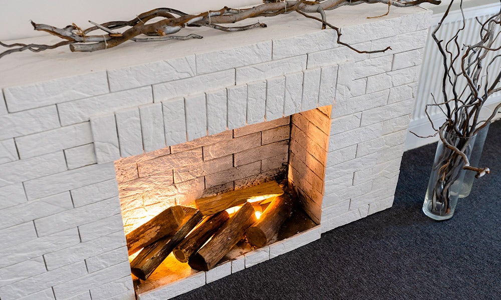 white brick fireplace with branch accents