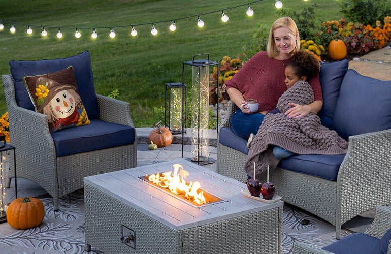 mother and child cuddling by outdoor fire pit