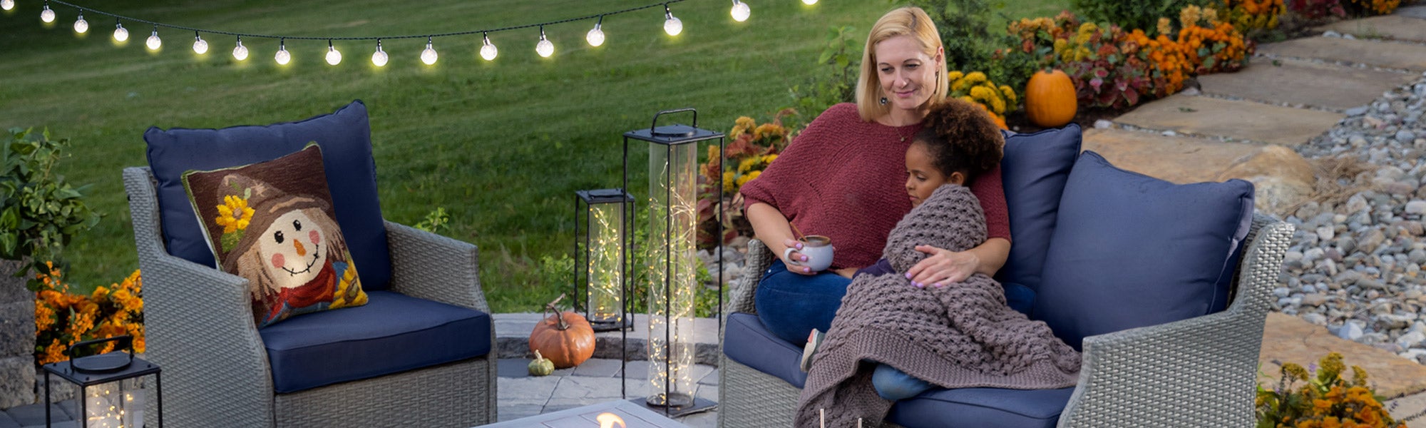 mother and child cuddling in front of outdoor fire pit