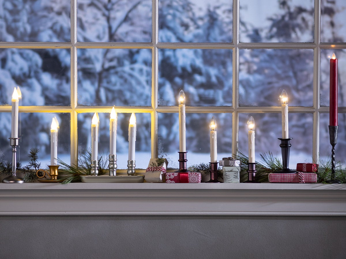 line of lighted candles in window