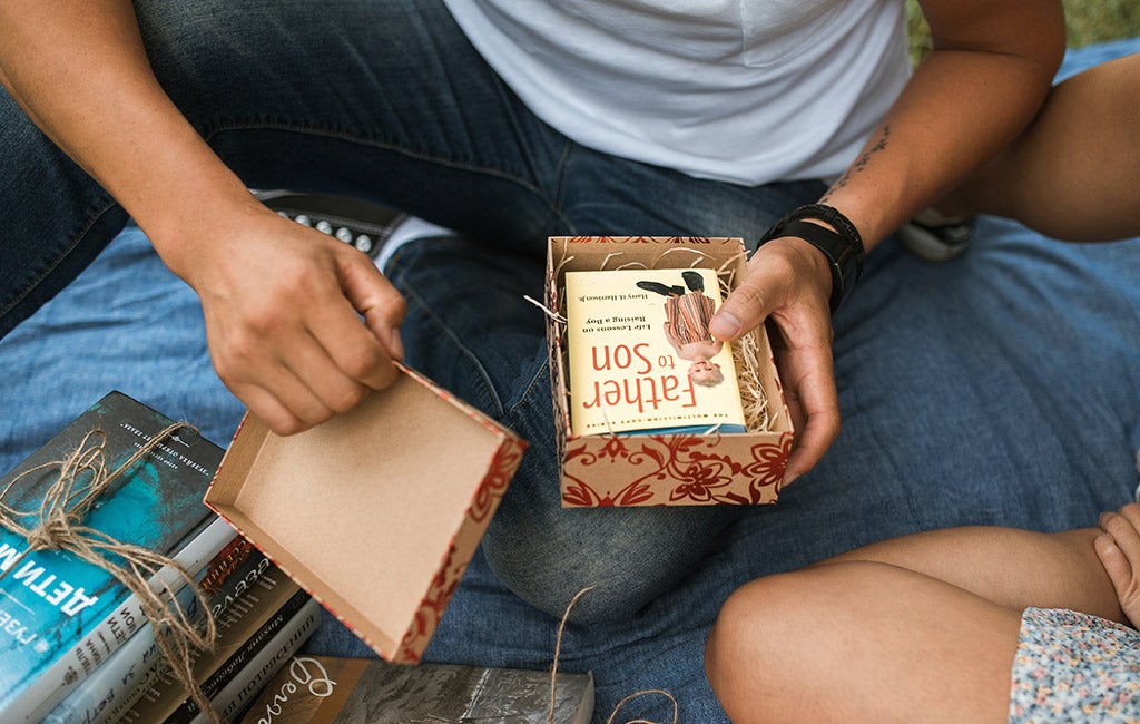 man opening gift with book inside