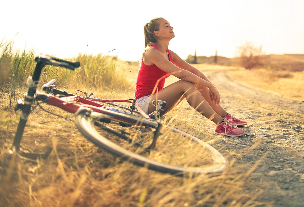 woman smiling beside bike