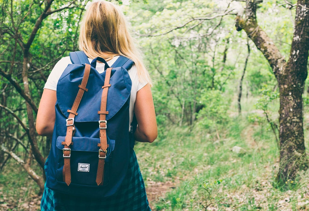 woman with backyard walking in forest