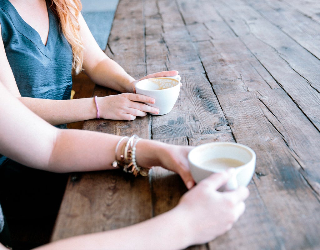 two woman talking and drinking coffee