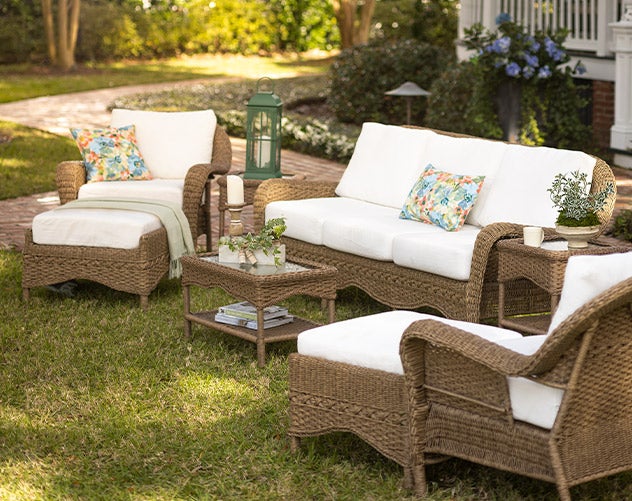 Prospect Hill Deep Seating Collection in brown all-weather wicker with cream white deep cushions in a grassy lawn.